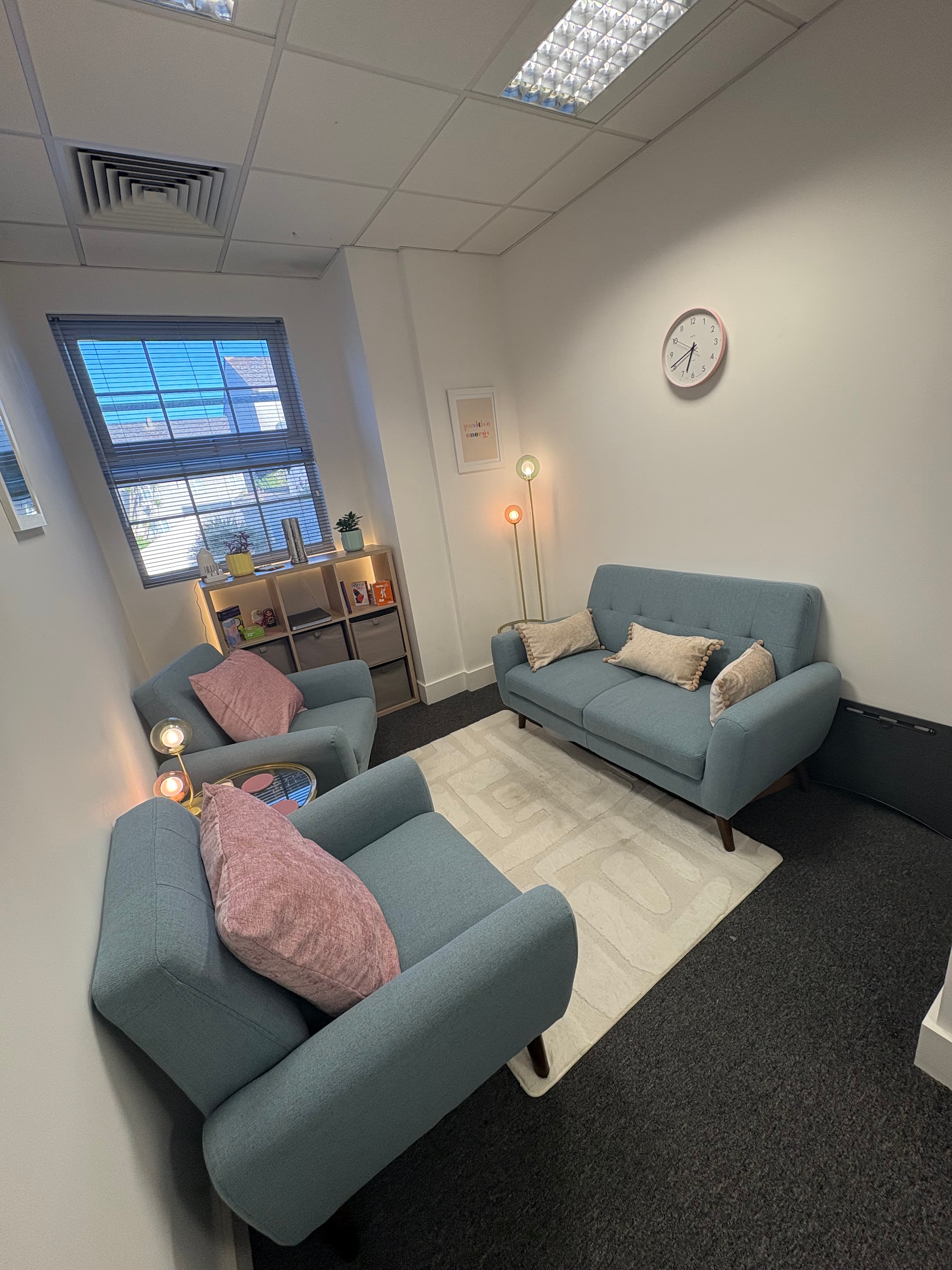 Warm and cozy counselling room with comfortable sofa where two people can sit and have a conversation in a safe, welcoming environment